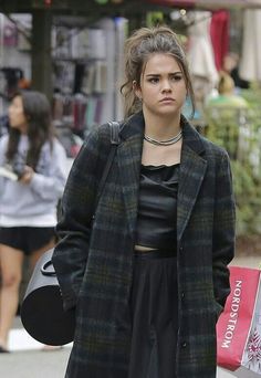 a young woman is walking down the street