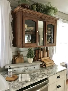 a kitchen counter with wooden cabinets and cutting boards on the top, next to a dishwasher