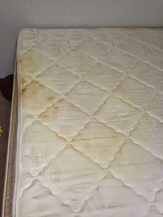 an unmade mattress is sitting on the floor in front of a wall with flowers