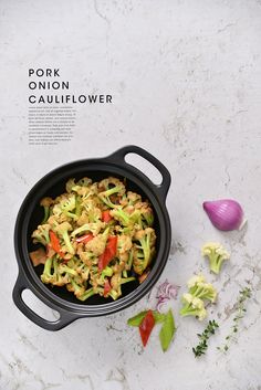 a pan filled with food sitting on top of a counter next to garlic and peppers