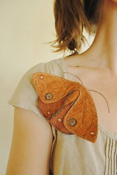 a close up of a person wearing a dress with a butterfly on it's chest