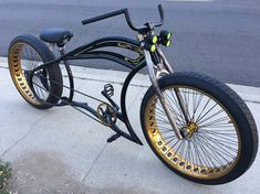 a black and gold bike parked on the side of a street next to a curb