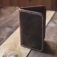 The Katahdin vertical leather card wallet is as classic as its namesake Mount Katahdin in Maine's Great North Woods. The full grain leather wallet is as tough as it is beautiful, calling to mind the pine laden forests surrounding Maine's tallest granite peak. Featuring four card pockets and 2 larger pockets in the back for money, business cards, or receipts, this sturdy wallet will stand the test of time. Made from leather sourced in Maine, the wallet features a rustic texture that will take on Rustic Leather Wallets With Card Slots, Rustic Leather Wallets, Rugged Bifold Wallet For Everyday Use, Rugged Leather Bifold Wallet, Artisan Leather Trifold Wallet For Daily Use, Artisan Brown Leather Trifold Wallet, Artisan Leather Trifold Wallet, Mount Katahdin, Full Grain Leather Wallet