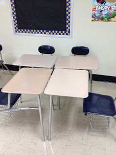 four empty desks in a classroom with a chalkboard on the wall