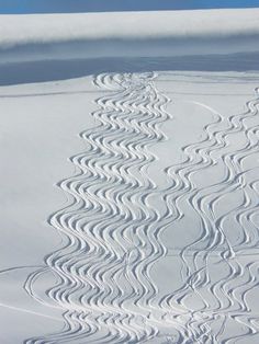 the tracks in the snow are made by skiers on skis and snowboards