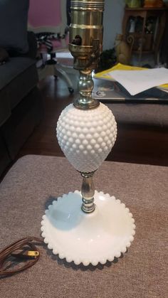 a white glass candle holder sitting on top of a table