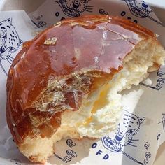 a half eaten doughnut sitting on top of a wrapper