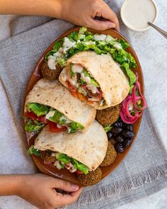 a plate with three pita sandwiches on it