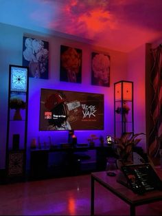 a living room filled with furniture and paintings on the wall above it's flat screen tv