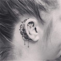 a woman's ear has a tattoo on it