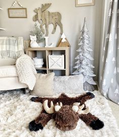 a stuffed animal laying on top of a white rug in front of a christmas tree