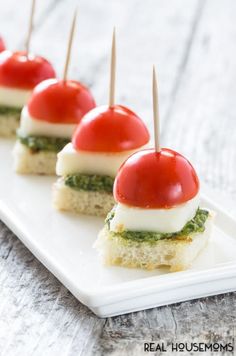 small appetizers with tomatoes and mozzarella are on a white platter