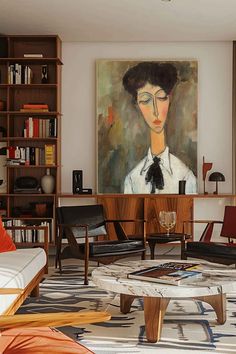 a living room filled with furniture and a painting on the wall above it's coffee table