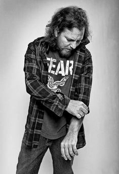 black and white photograph of a man with long hair wearing a flannel shirt