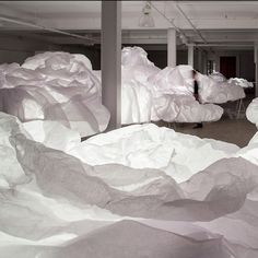 there are many white paper sculptures in the room that looks like they have been folded up