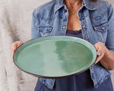 a woman holding a green plate in her hands