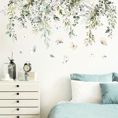 a bed room with a neatly made bed and wall decals