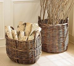 two wicker baskets sitting on the floor next to each other in front of a fireplace