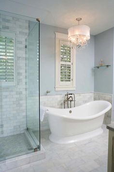 a white bath tub sitting next to a walk in shower