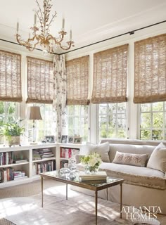 a living room filled with furniture and windows covered in shades of bamboo covering the window