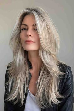 Woman with long platinum blonde hair and face-framing layers. Platinum Blonde Dimensional Hair, White Face Framing Highlights, Blonde Layered Long Hair, Long Hair Framing Face, Blonde Layered Hair With Curtain Bangs, Layered Blonde Hair Long, Blonde Hair With Face Framing Highlights, How To Cut Your Own Hair In Layers Long, Face Framing Layers Long Hair Side Part