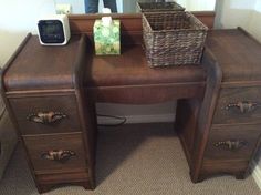 a wooden desk with two drawers and a wicker basket sitting on top of it