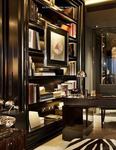 a living room filled with furniture and bookshelves next to a large mirror on the wall