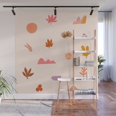 a living room with an orange and pink wall decal on the wall next to a book shelf