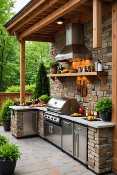 an outdoor kitchen with stainless steel appliances and grilling area, surrounded by greenery