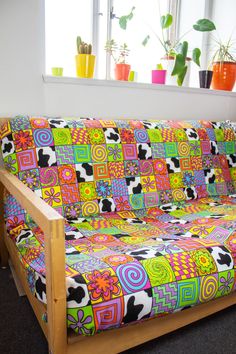 a brightly colored couch sitting in front of a window