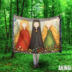 a woman holding up a blanket with three princesses on it in the middle of a forest