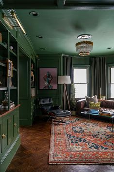 a living room with green walls and wooden flooring, leather couches and rugs