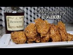 a white plate topped with fried chicken next to a bottle of hennyduling