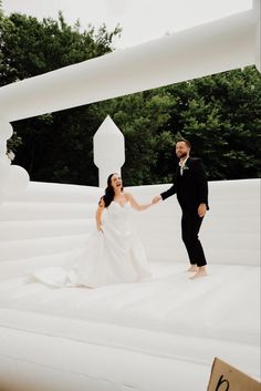 a bride and groom standing on an inflatable structure