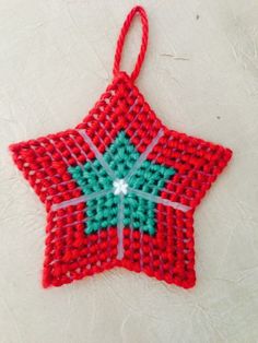 a red and green star ornament on a white surface