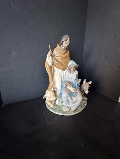 a figurine of jesus and baby jesus on a black surface