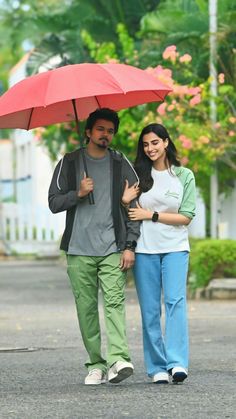 a man and woman walking down the street under an umbrella