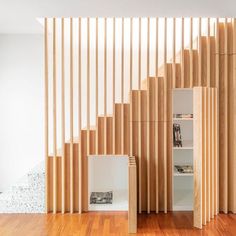 a room with wooden slats on the wall and wood flooring in front of it