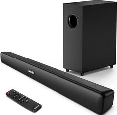 an image of a sound bar with remote control and subwoofer on the side