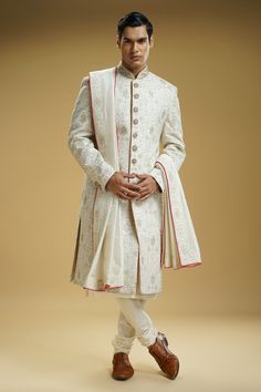 Off-white silk dupion sherwani with floral jaali embroidery. Comes with a cotton silk kurta, churidar, and a stole.
Component: 4
Pattern: Embroidered
Type Of Work: Floral jaali
Neckline: Mandarin collar
Sleeve Type: Full
Fabric: Silk dupion, Kurta : Cotton silk
Color: Off White
Other Details: 
Embellished buttons on front placket
Embroidered borders on stole
Occasion: Groom, Wedding - Aza Fashions Stole For Men, Embroidered Sherwani, Embellished Buttons, Kurta Cotton, Silk Kurta, Fabric Silk, Churidar, White Silk, Mandarin Collar