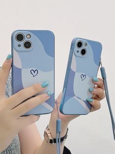 two women holding up their cell phones with the same phone case on them, one is blue and the other has hearts