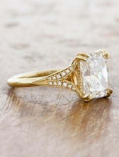 an antique style diamond ring sits on a table