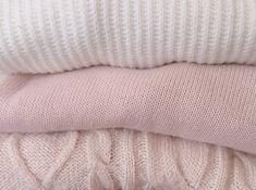 three sweaters stacked on top of each other