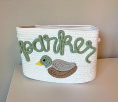 a white basket with a green duck and the word fearless written in large letters on it