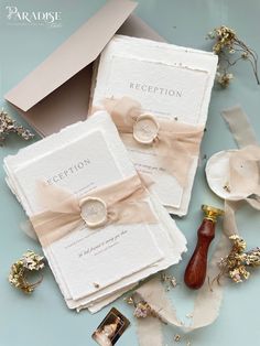 the wedding stationery is laid out on top of each other and tied with ribbon