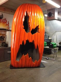 a large pumpkin shaped like a jack - o'- lantern in a workshop area