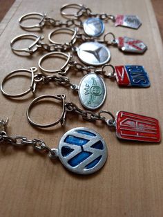 a bunch of key chains that are on top of a wooden table with some badges attached to them