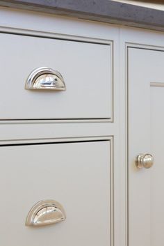 two drawers with handles and knobs are shown in this kitchen cabinet door detail photo