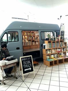 a person sitting in front of a book truck