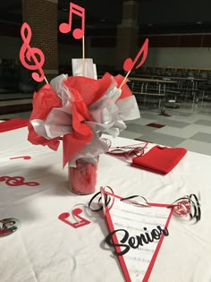 a centerpiece with music notes and streamers in a vase on top of a table